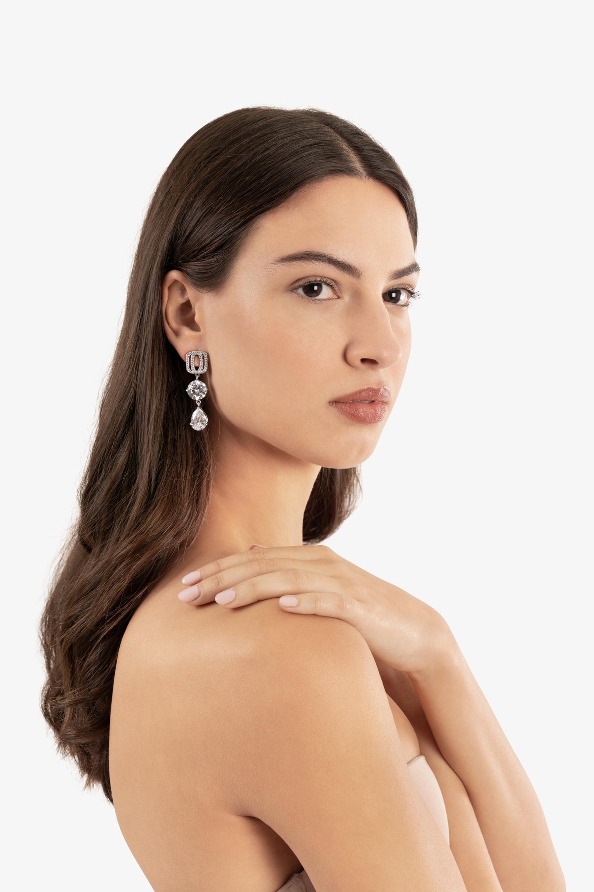 Woman wearing a pair of earrings on a white background
