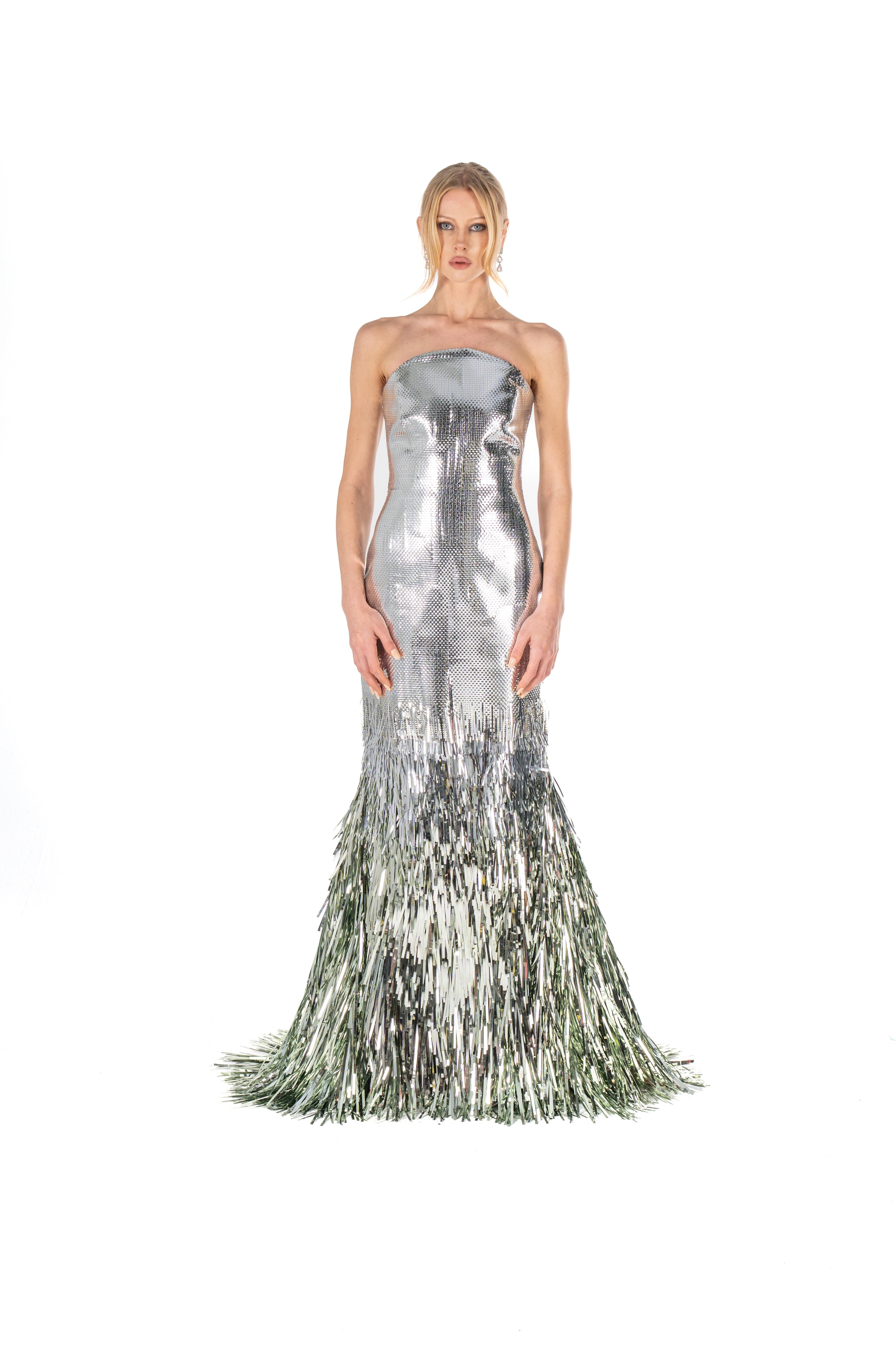 Silver strapless gown with feathered skirt on a white background