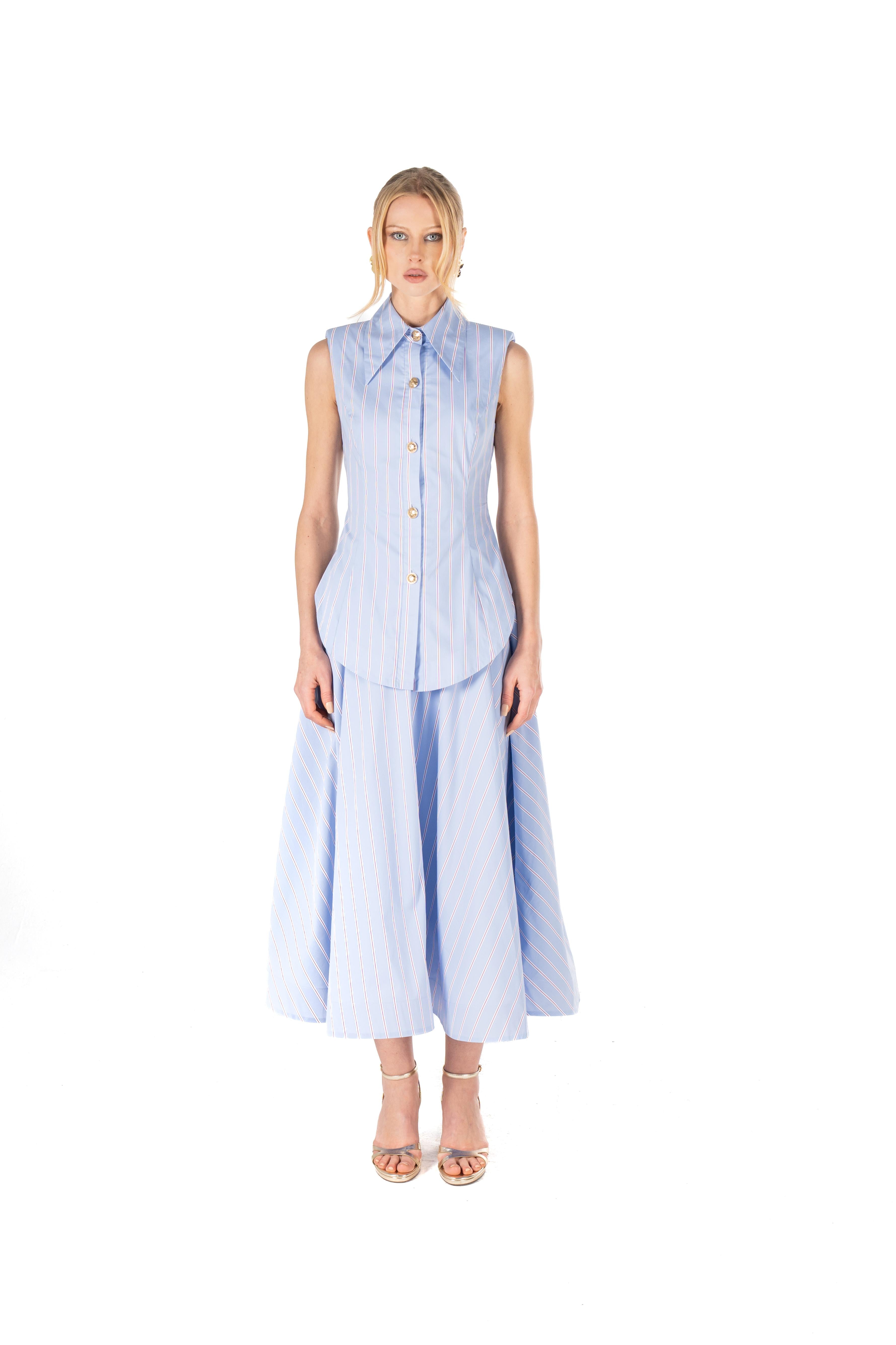 Woman wearing a sleeveless blue checkered dress with a long skirt on a white background