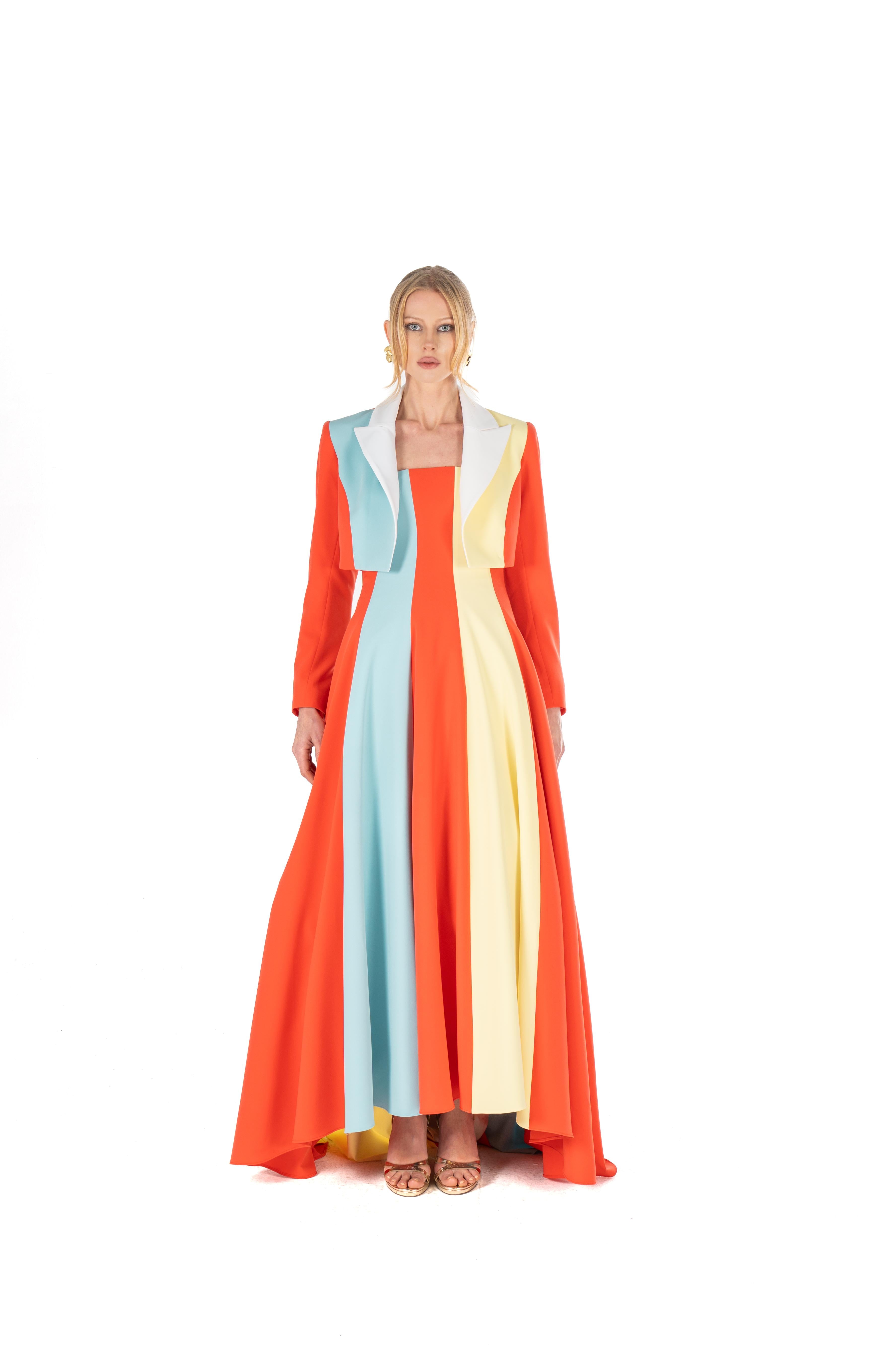 Woman wearing a long, colorful dress with vertical stripes on a white background