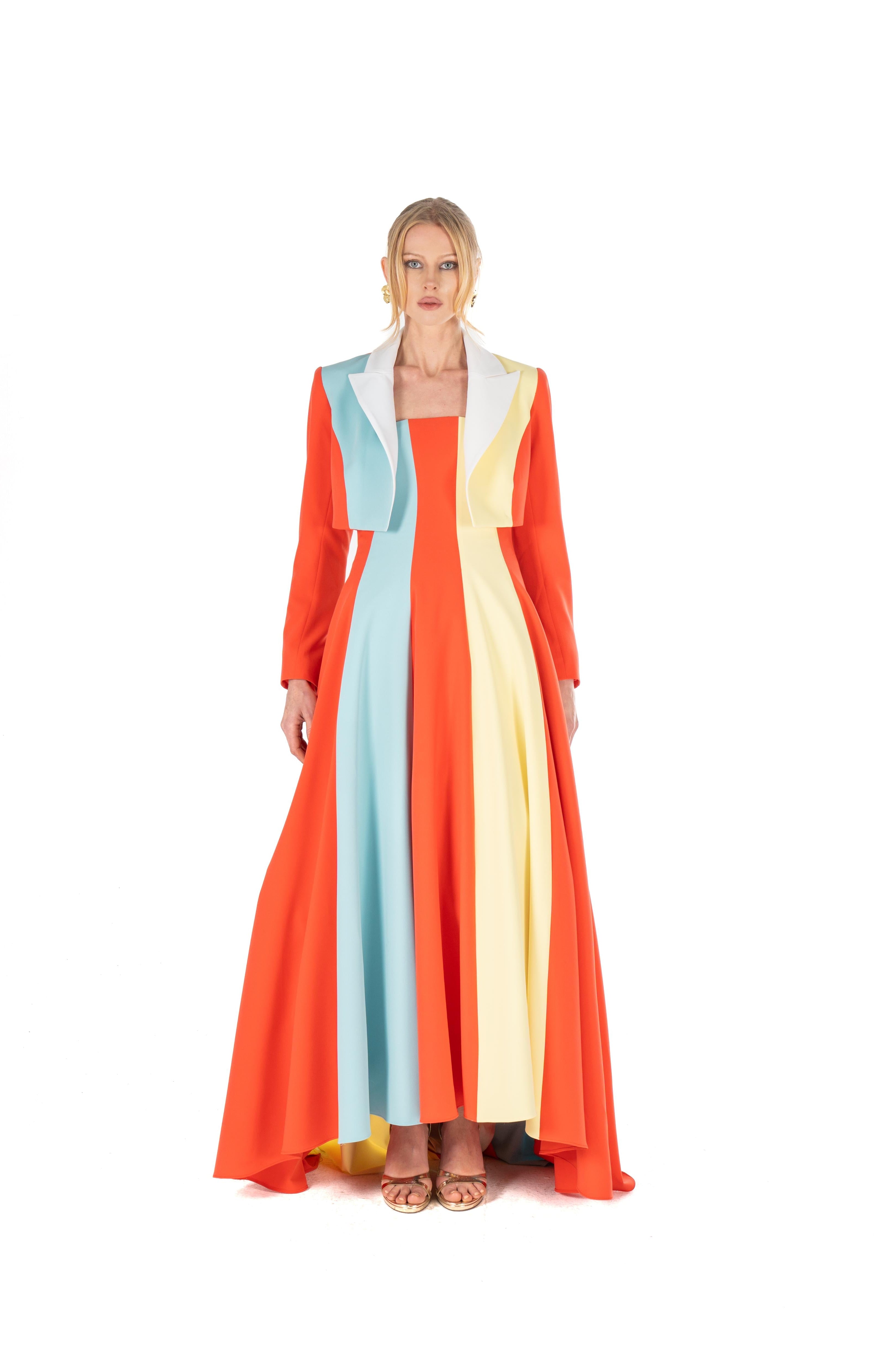 Woman wearing a long, colorful dress with vertical stripes on a white background