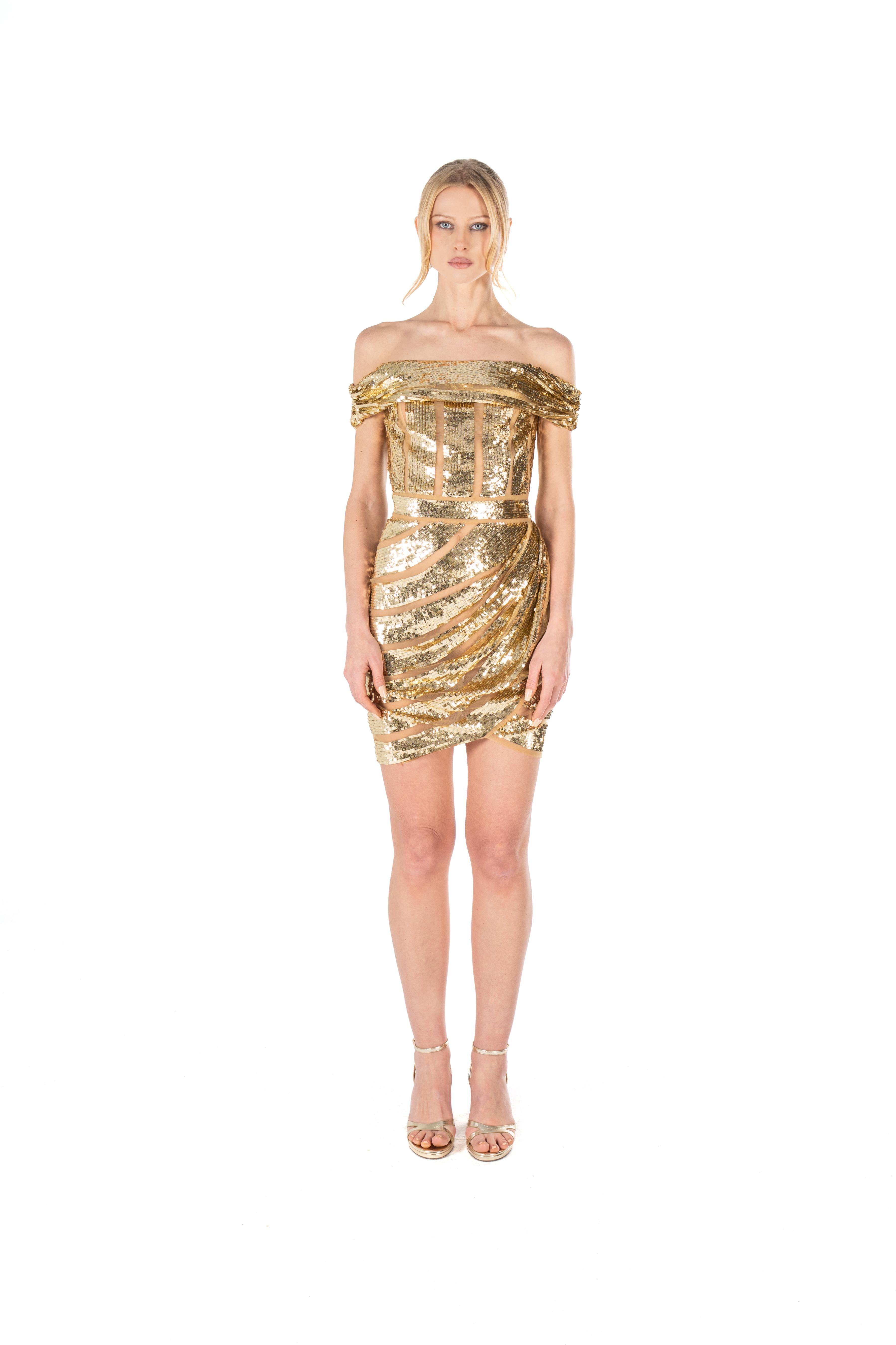 Gold sequin dress worn by a model on a white background