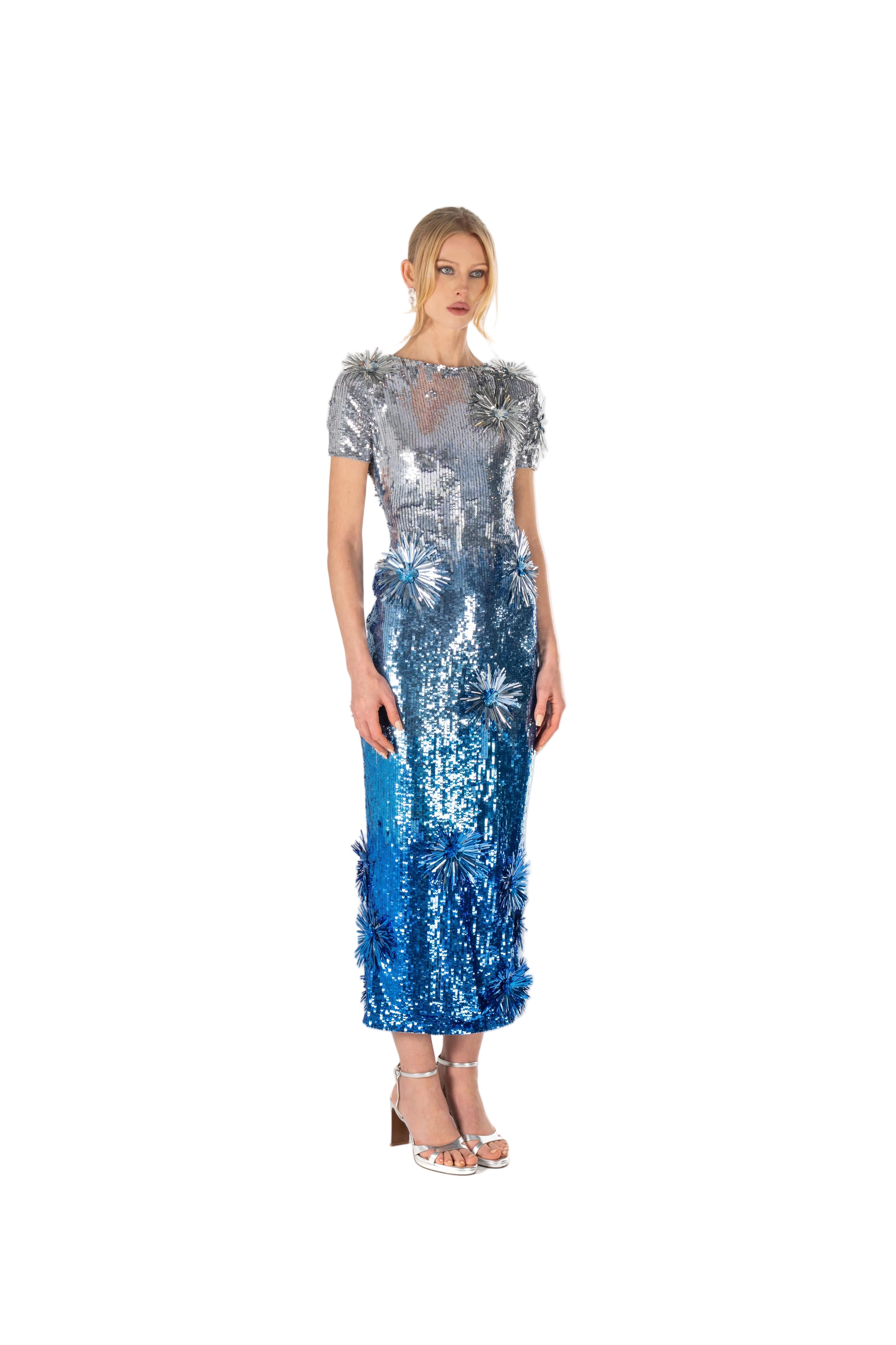 Woman wearing a silver and blue sequin dress on a white background