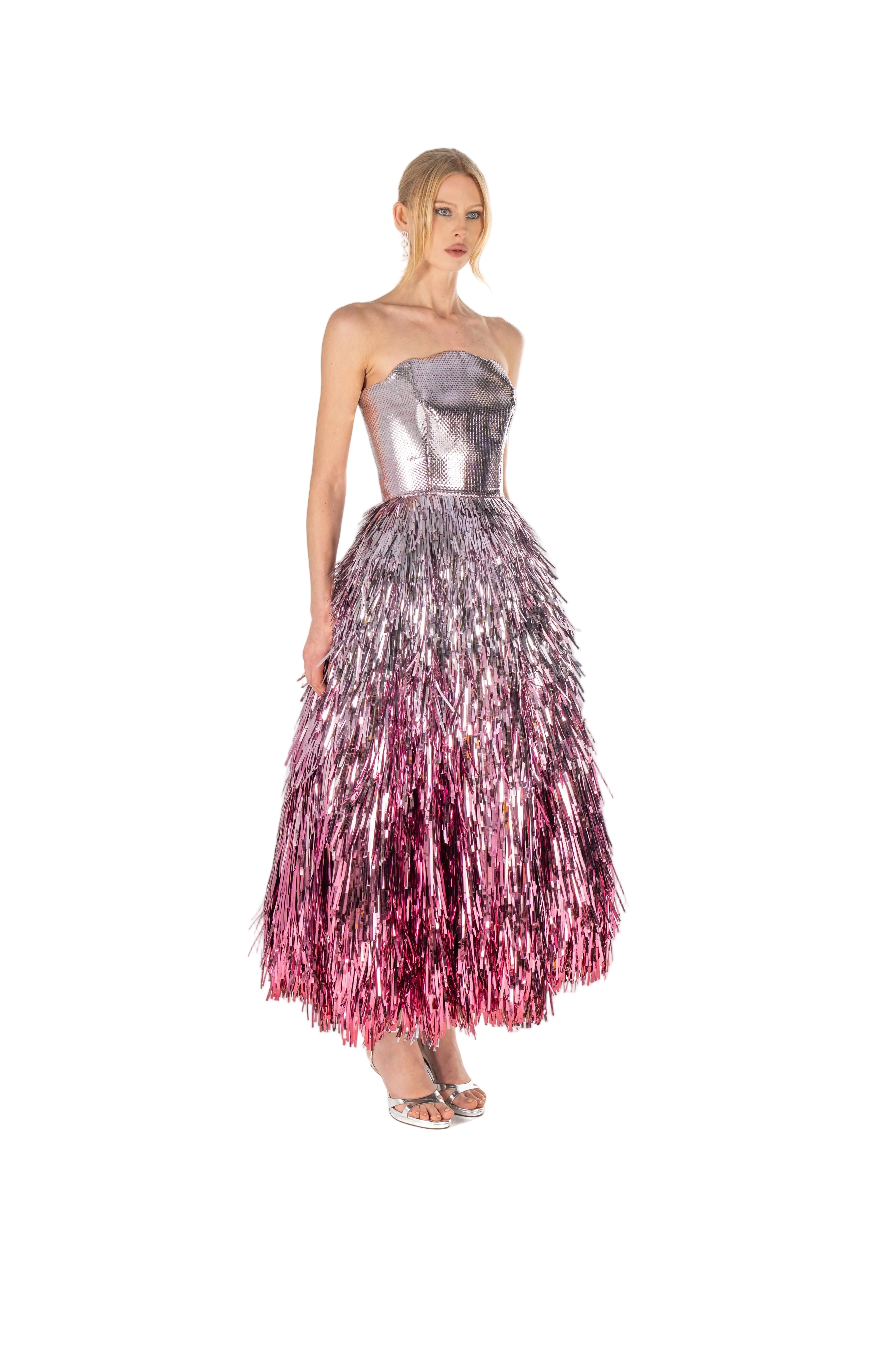 Model wearing a strapless metallic dress with a gradient from silver to pink on a white background