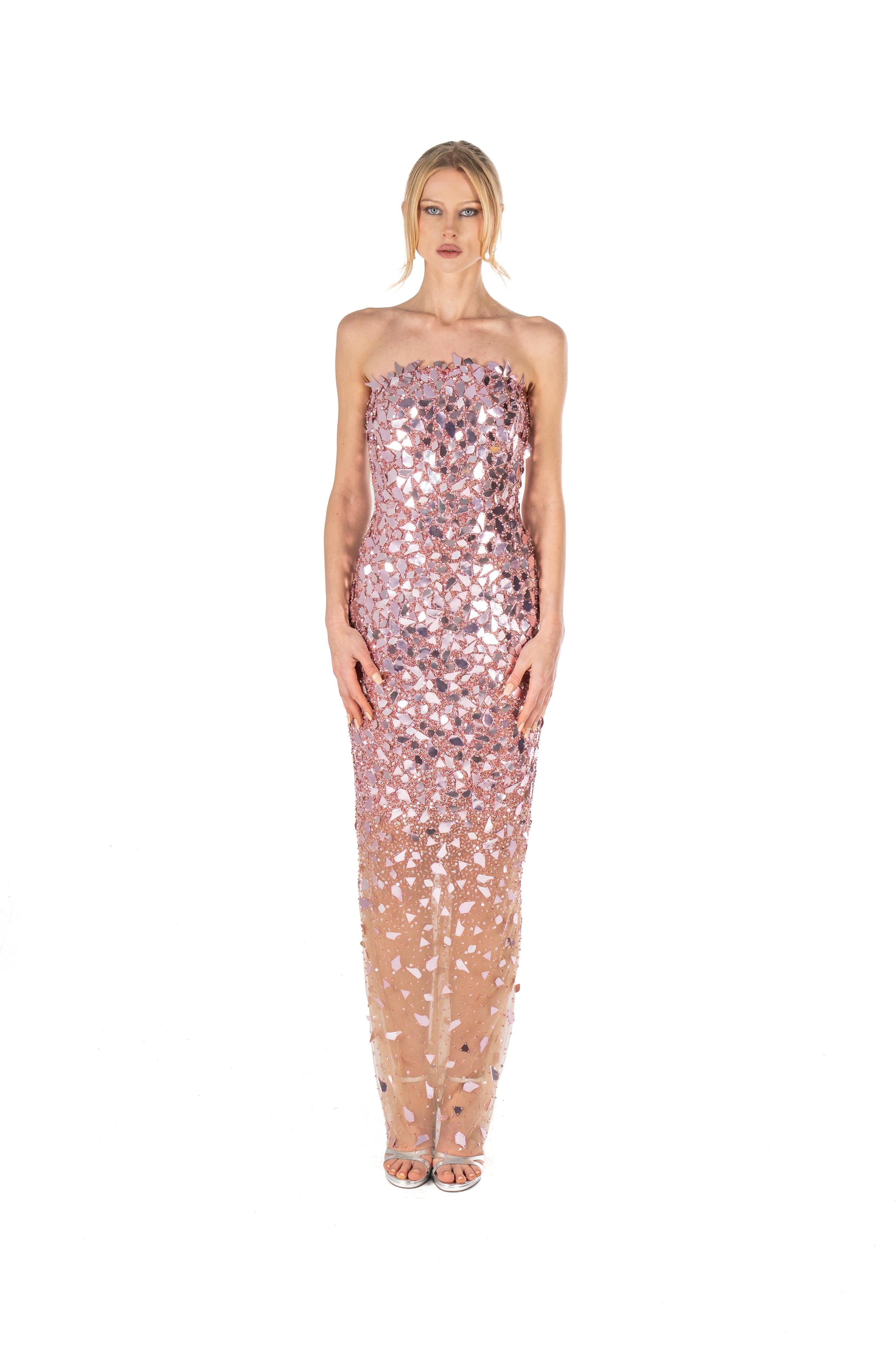 Woman wearing a strapless, sequined dress with a gradient effect on a white background